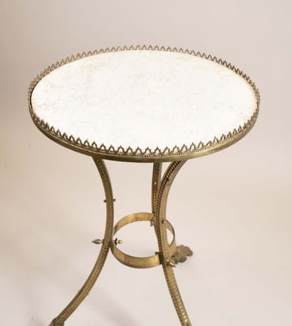 A bronze and brass pedestal table resting...