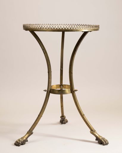 A bronze and brass pedestal table resting...