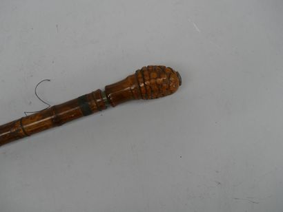 A large bamboo cane fitted with a hook and...