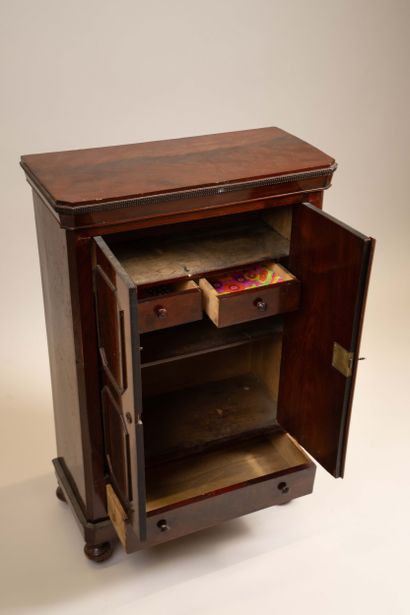 A small, chamfered mahogany cabinet with...
