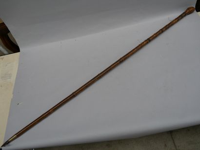 A large bamboo cane fitted with a hook and...