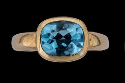 Ring featuring an oval-shaped, treated blue...