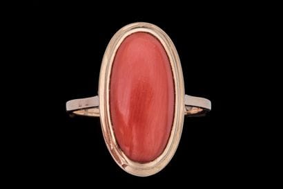 Marquise-shaped ring set with a coral cabochon...