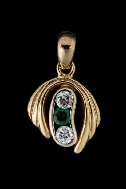 Pendant set with a round-shouldered emerald...