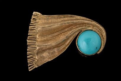 Vintage brooch featuring a draped trim design...