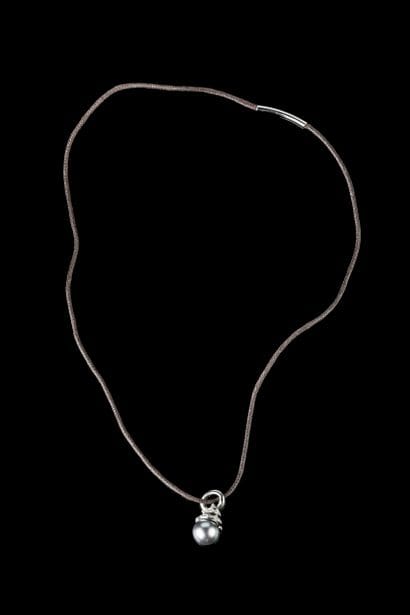 A large clasp-back pendant featuring a Tahitian...