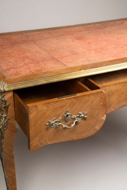A flat, scalloped-edge desk made of rosewood...