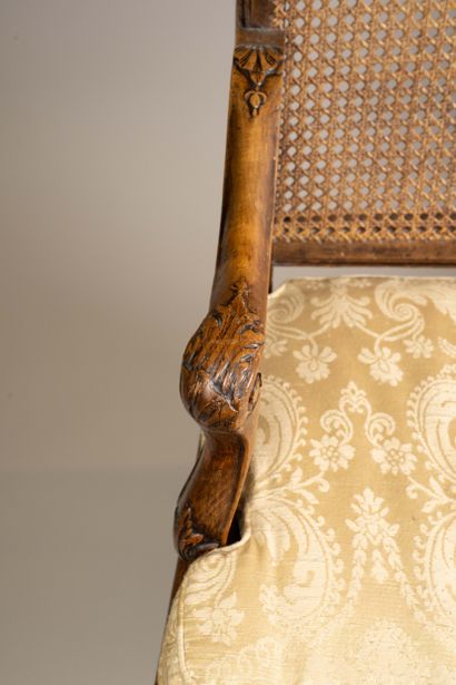 A cane-seated armchair with a flat back made...