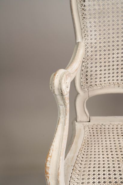 A cane-seated sofa with molded wood and a...