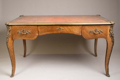 A flat, scalloped-edge desk made of rosewood...