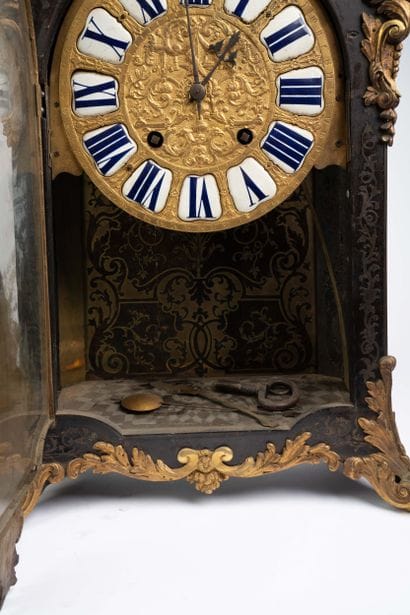 Wall clock with a brown tortoiseshell-veneered...