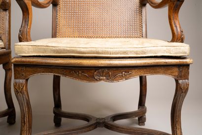 A cane-seated armchair with a flat back made...