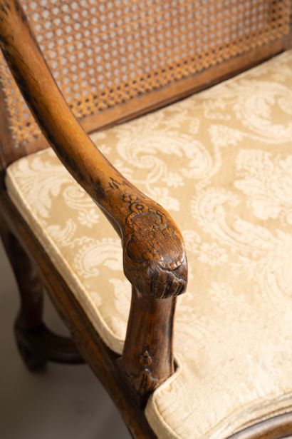 A cane-seated armchair with a flat back made...