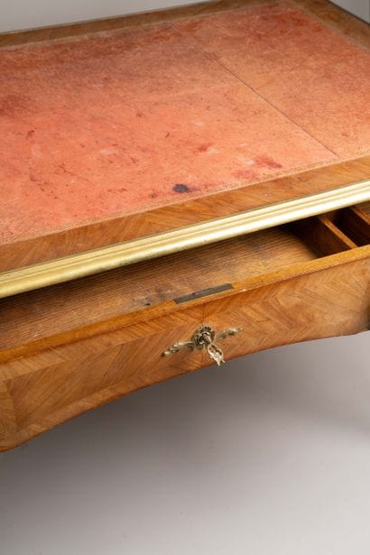 A flat, scalloped-edge desk made of rosewood...