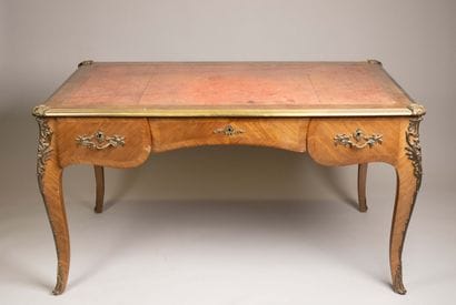A flat, scalloped-edge desk made of rosewood...