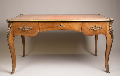 A flat, scalloped-edge desk made of rosewood...