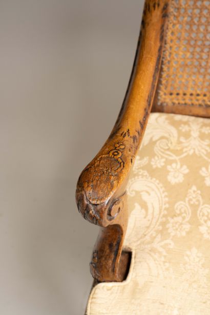 A cane-seated armchair with a flat back made...