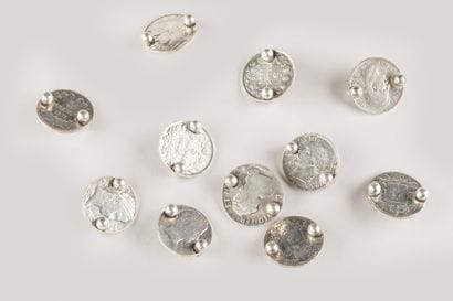 11 silver coins, mounted in knife holders
268...