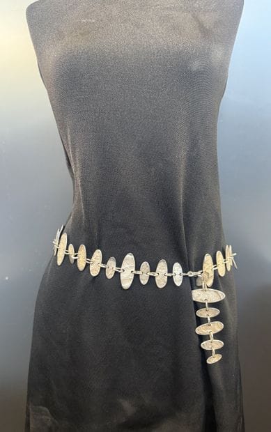 Metal belt featuring hammered, oval-shaped...