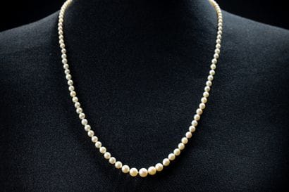 A cascading necklace featuring 124 white...