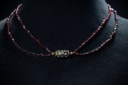 A two-row necklace of small faceted beads...