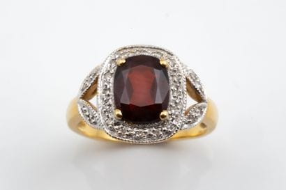 Ring featuring a cushion-cut garnet set in...