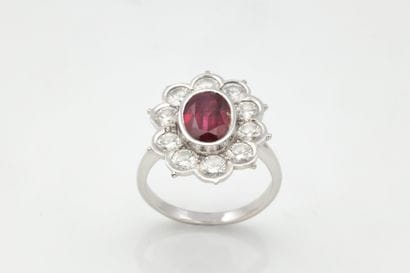 Daisy ring centered on an oval ruby in a...
