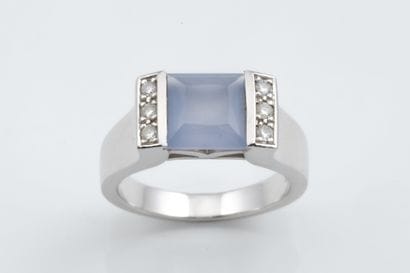 A ring featuring a square, faceted mauve-blue...