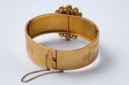 Clasp-style bangle featuring a central rosette...