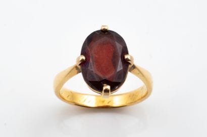 Ring featuring a faceted oval rust-brown...