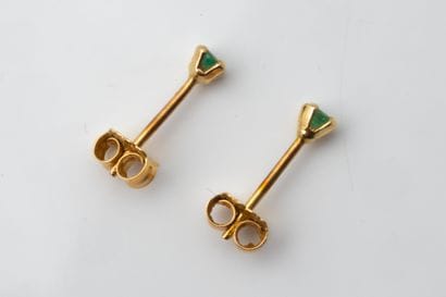 A pair of stud earrings, each set with a...