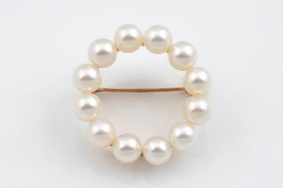 A brooch in the shape of a crown or circle,...