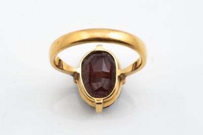 Ring featuring a faceted oval rust-brown...