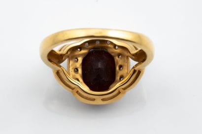 Ring featuring a cushion-cut garnet set in...