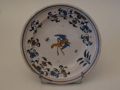 Assiette ronde en faïence à décor centré...