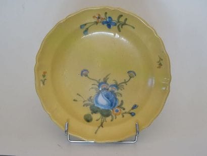 Assiette en faïence à fond jaune à décor...