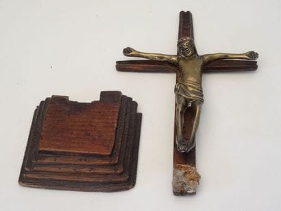 Sur un socle en bois, un Christ en croix...