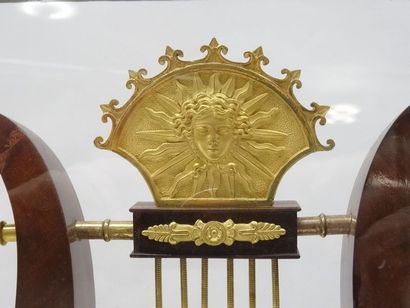 Dans une cage en verre, pendule lyre en acajou,...