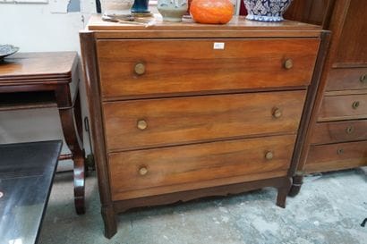 Une commode en bois de placage ouvrant par...
