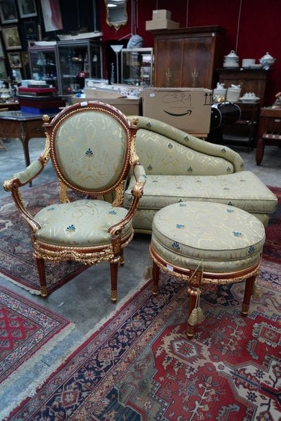 Un fauteuil et un pouf en bois doré recouvert...