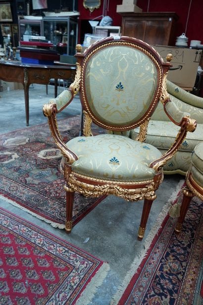 Un fauteuil et un pouf en bois doré recouvert...