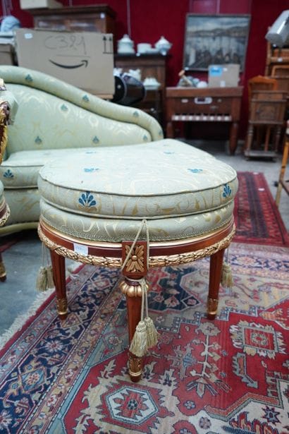 Un fauteuil et un pouf en bois doré recouvert...