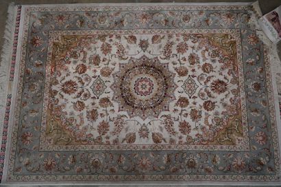 Tapis en laine et soie à décor floral polychrome...