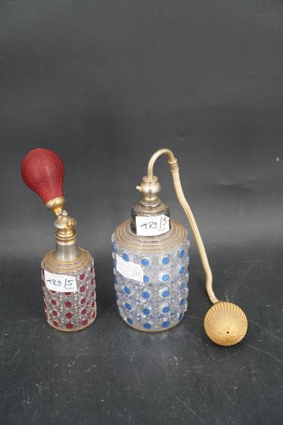 Deux vaporisateurs en verre moulé. En l'...