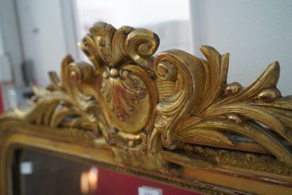 Important miroir en bois et composition doré,...