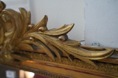Important miroir en bois et composition doré,...