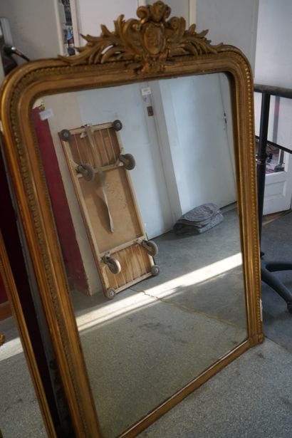 Important miroir en bois et composition doré,...