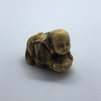Netsuke en os sculpté figurant un personnage...