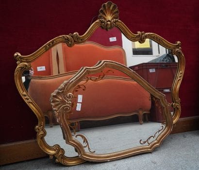 Deux miroirs en bois doré; un de forme écusson...