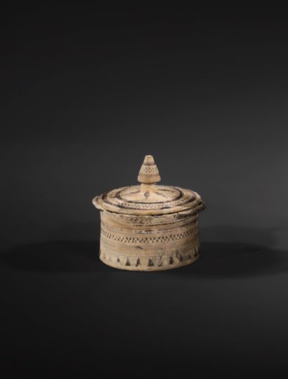 CIRCULAR PYXIS
Fitted with two small V-shaped...